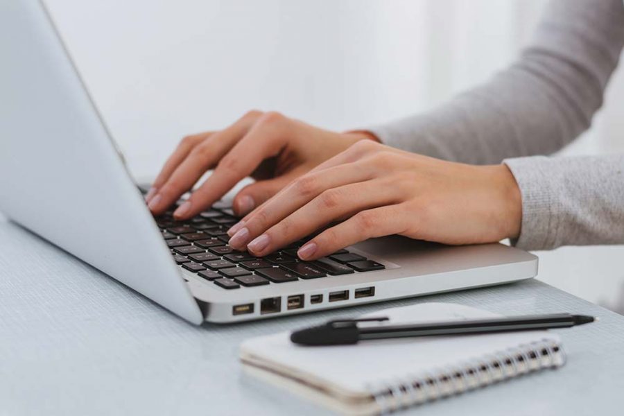 A person typing on a laptop keyboard