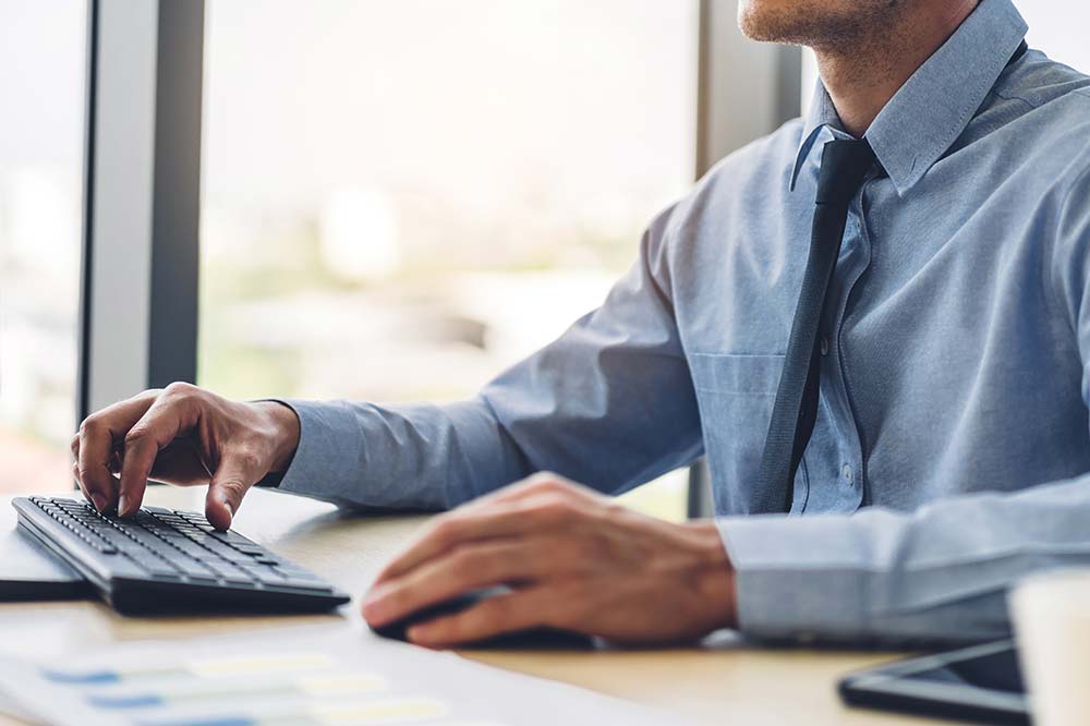 A person typing on a computer keyboard