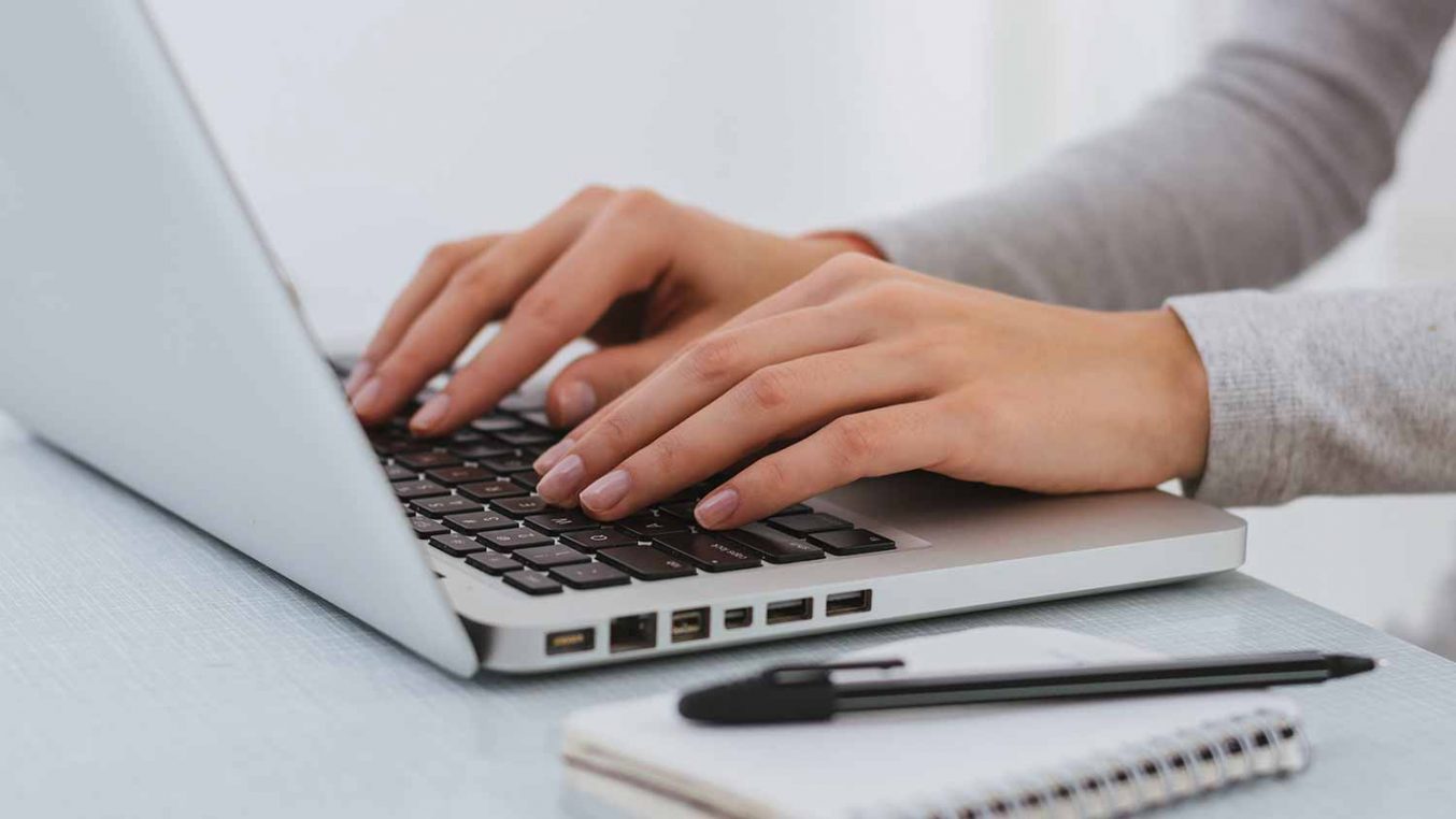 A person typing on a laptop keyboard