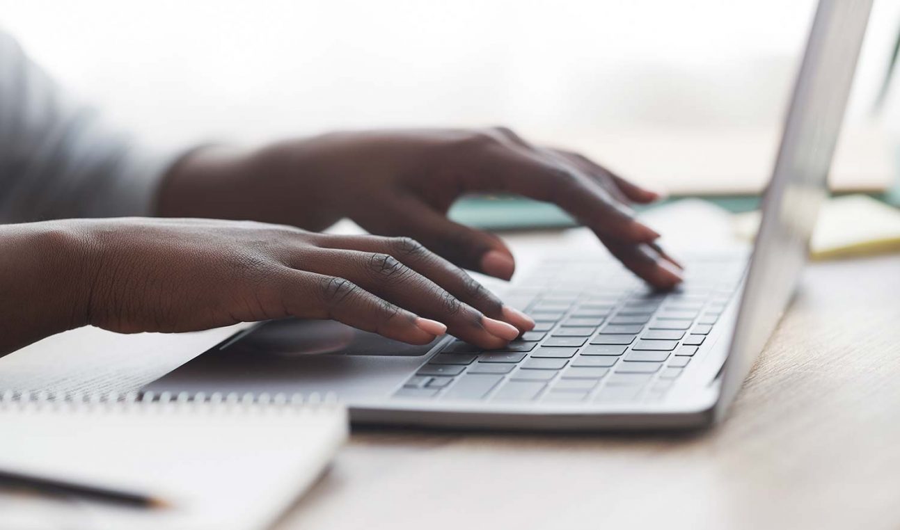 A person typing on a laptop keyboard