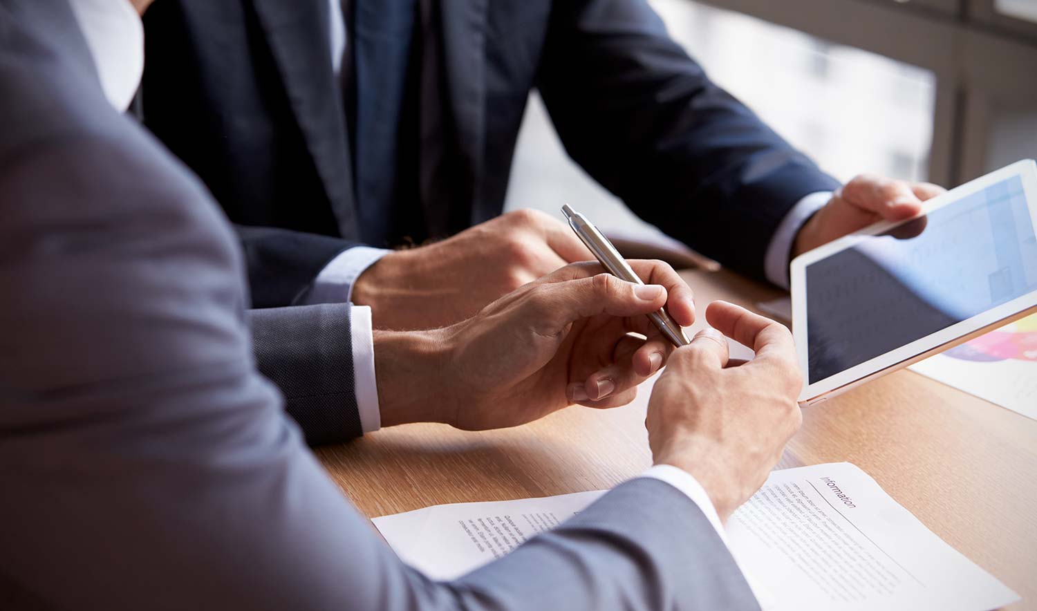 A person holding a pen and a person holding a tablet device