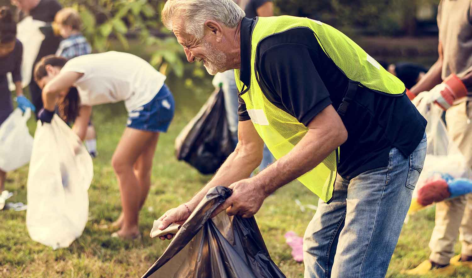 A group of people picking up litter in a field