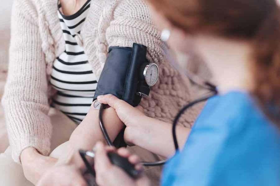 An elderly person having their blood pressure taken