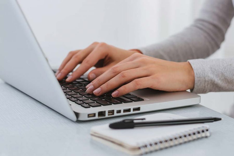 A person typing on a laptop keyboard