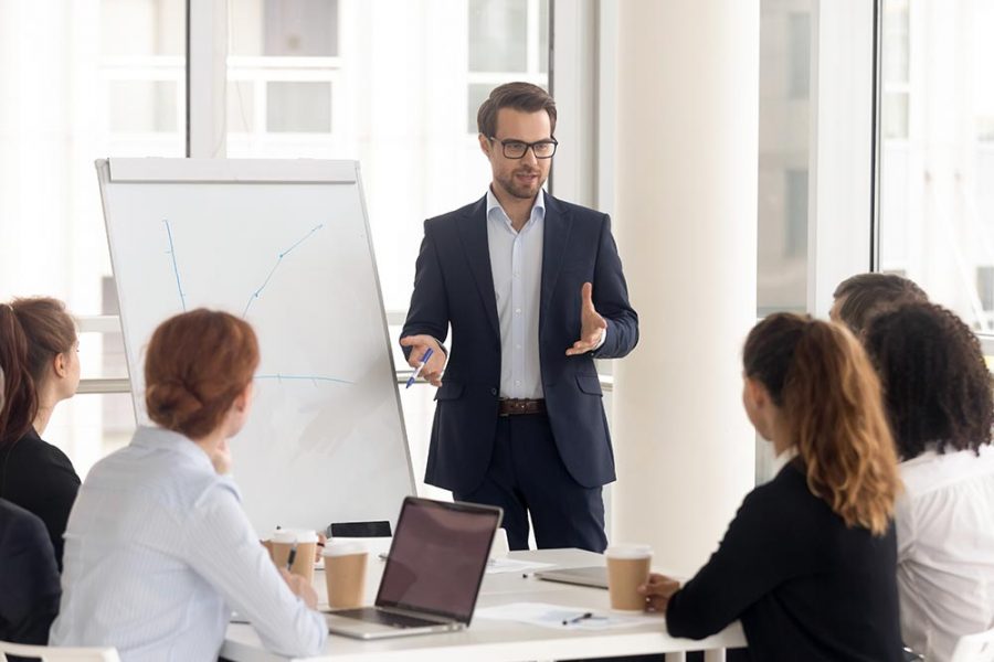 A person giving a presentation next to a flipchart