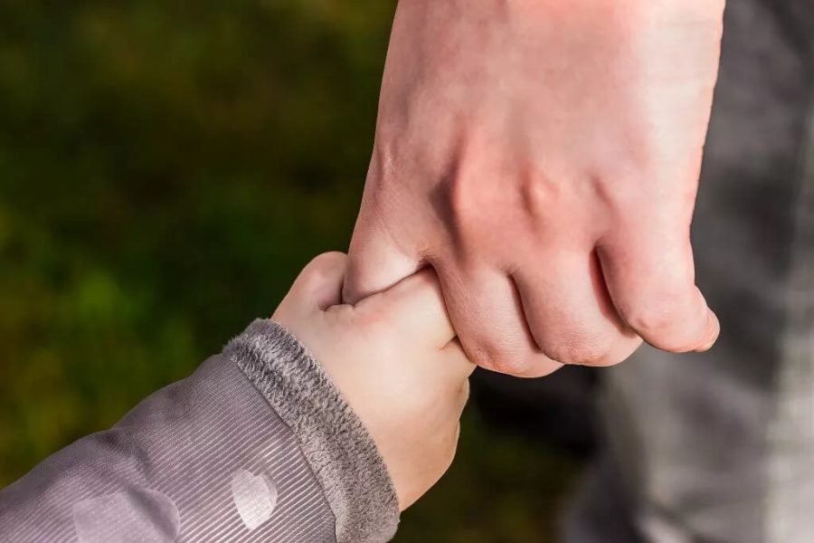 A person holding hands with a child