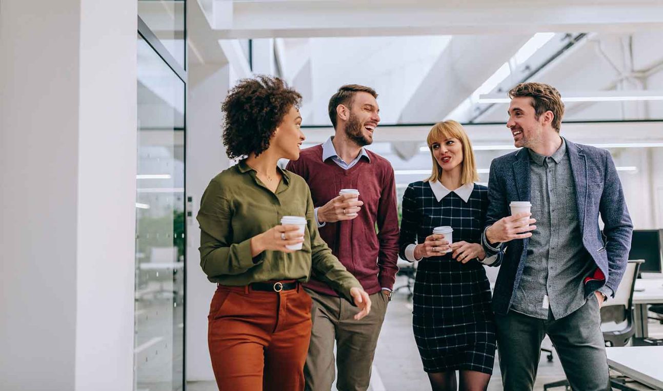 A group of people laughing in an office environment