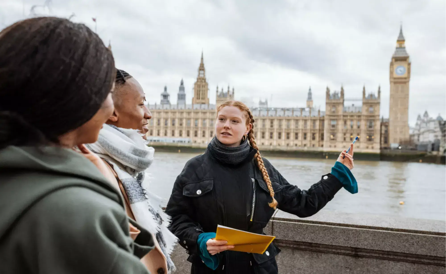 A guide giving a tour opposite the Houses of Parliament